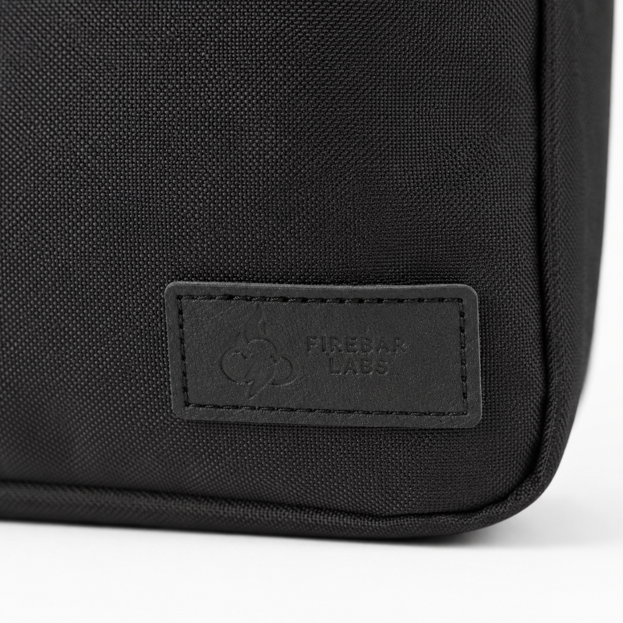 FireBar Labs Essential Messenger Bag — Black bag with embossed label detail