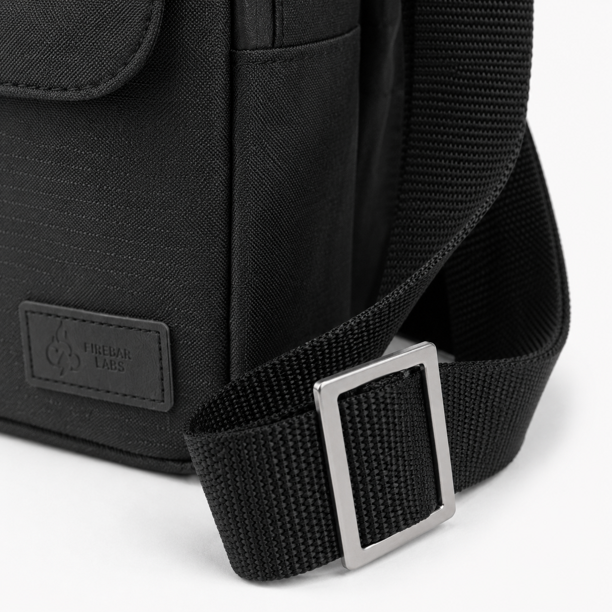 FireBar Labs Essential Messenger Bag — Black bag with textured fabric and label